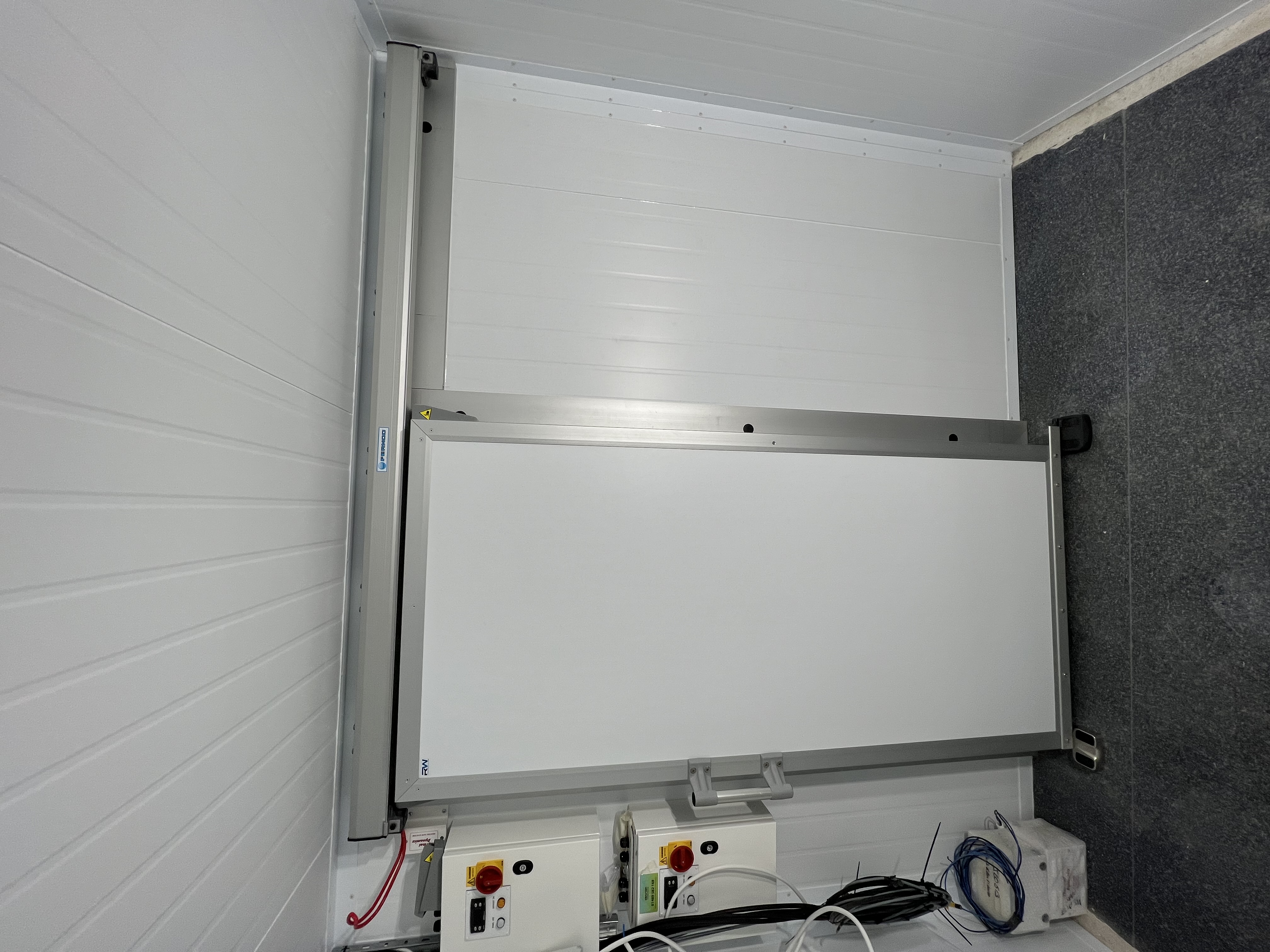 Insulated vertical sliding door in controlled environment